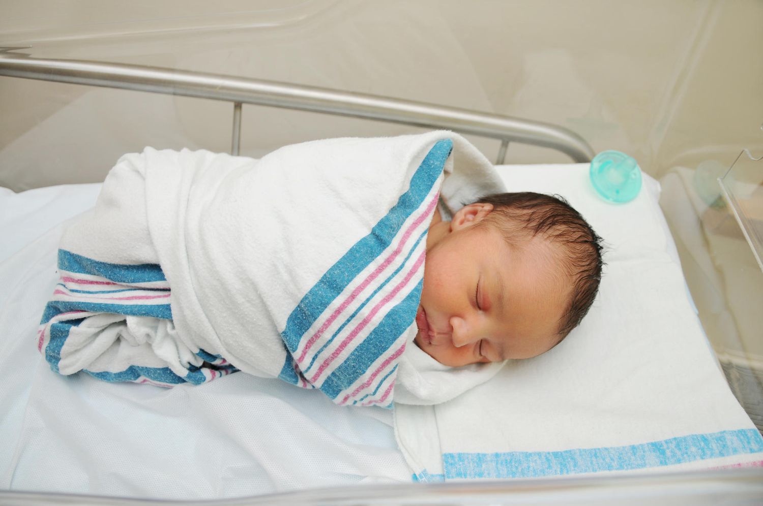 newborn baby in pink and blue hospital blanket