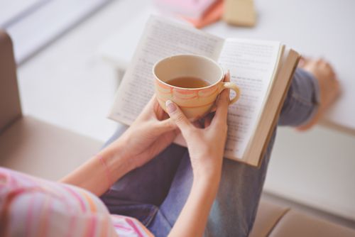 Woman reading with coffee in hand