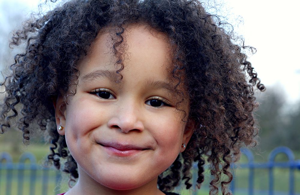 smiling young girl with curly black hair