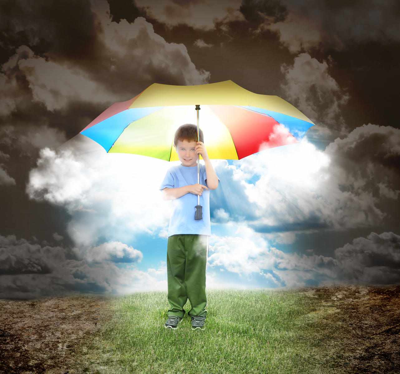 boy standing under a colorful umbrella