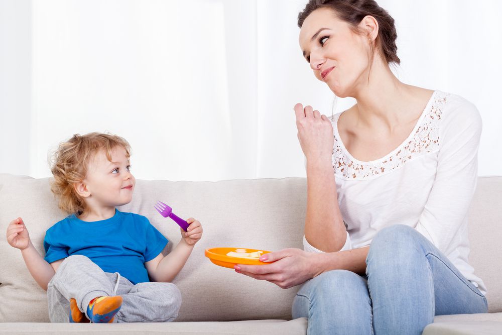 Mom and Toddler Eating on Couch