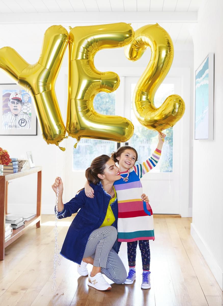 Mom and daughter holding balloon that says yes