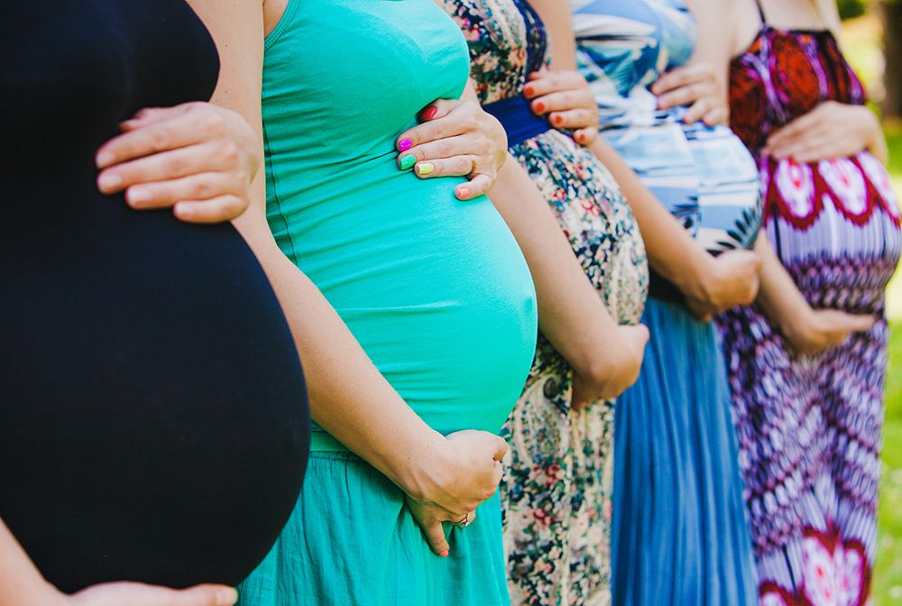 group of pregnant women holding bellies