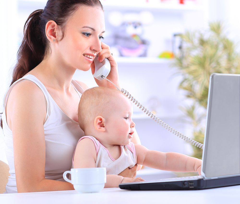 Mom working on computer with baby on lap