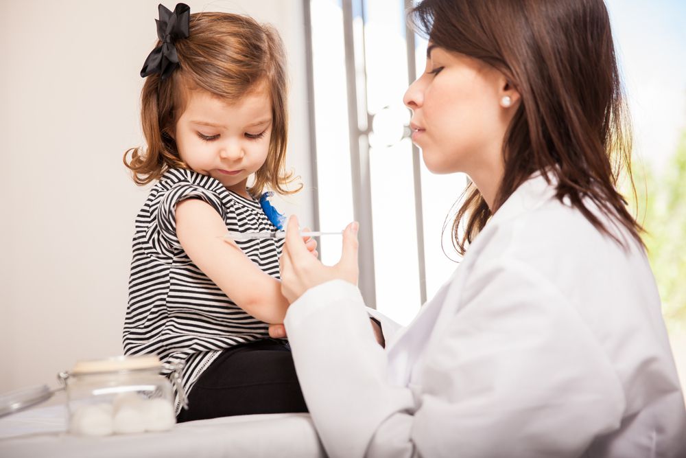 little girl getting flu shot from doctor