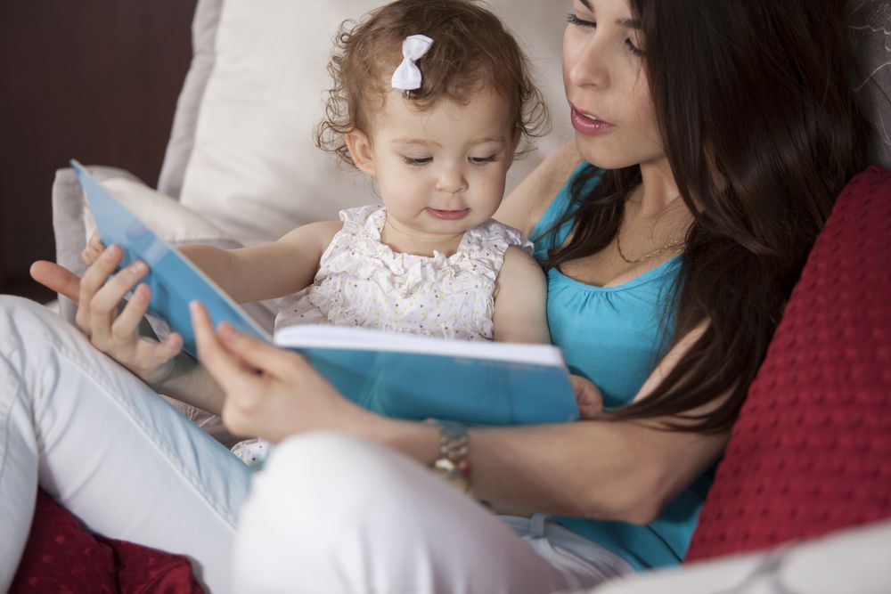 babysitter reading to little girl