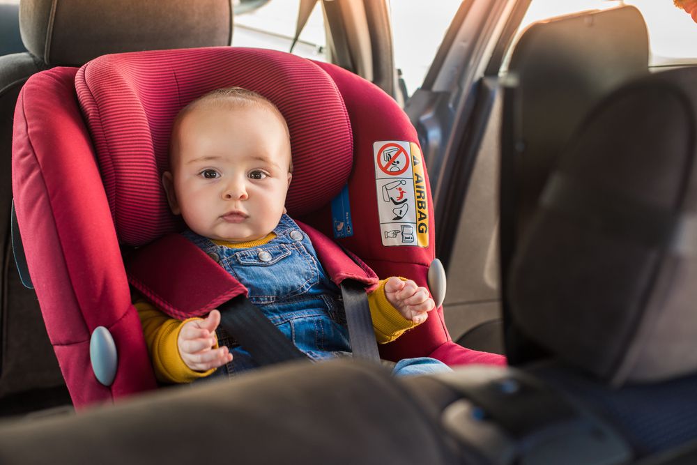 baby in rear facing car seat, red