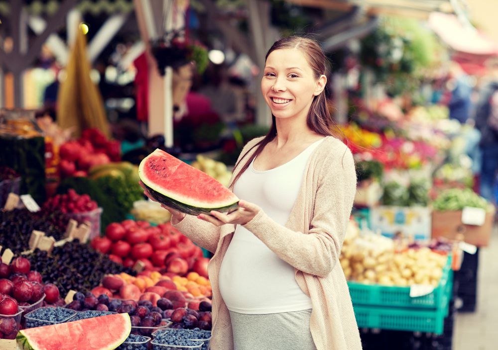 pregnant woman holding watermelon