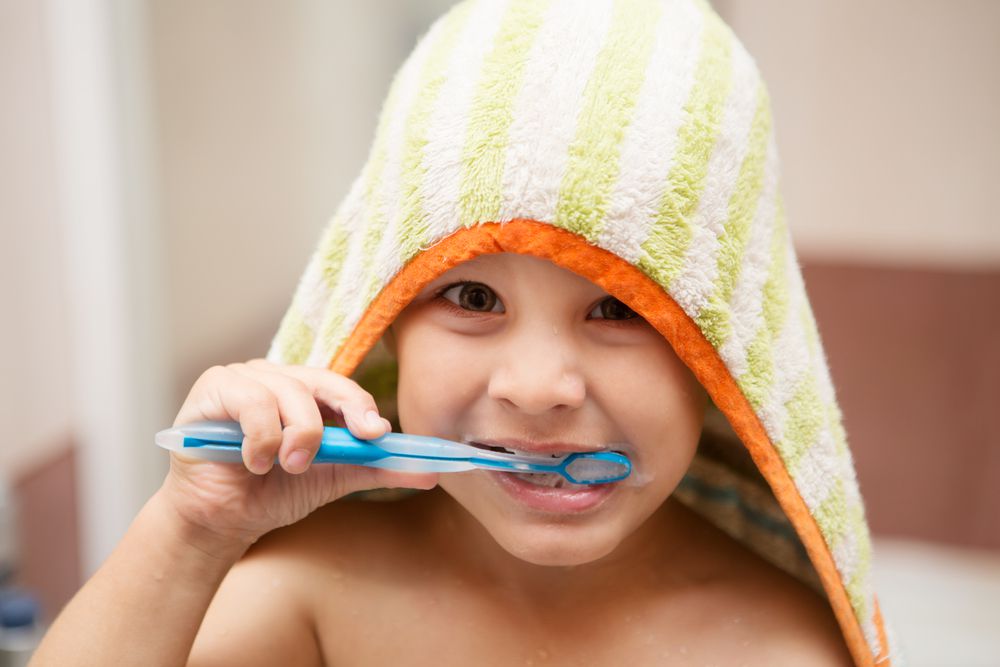 Boy Brushing Teeth Wearing Towel
