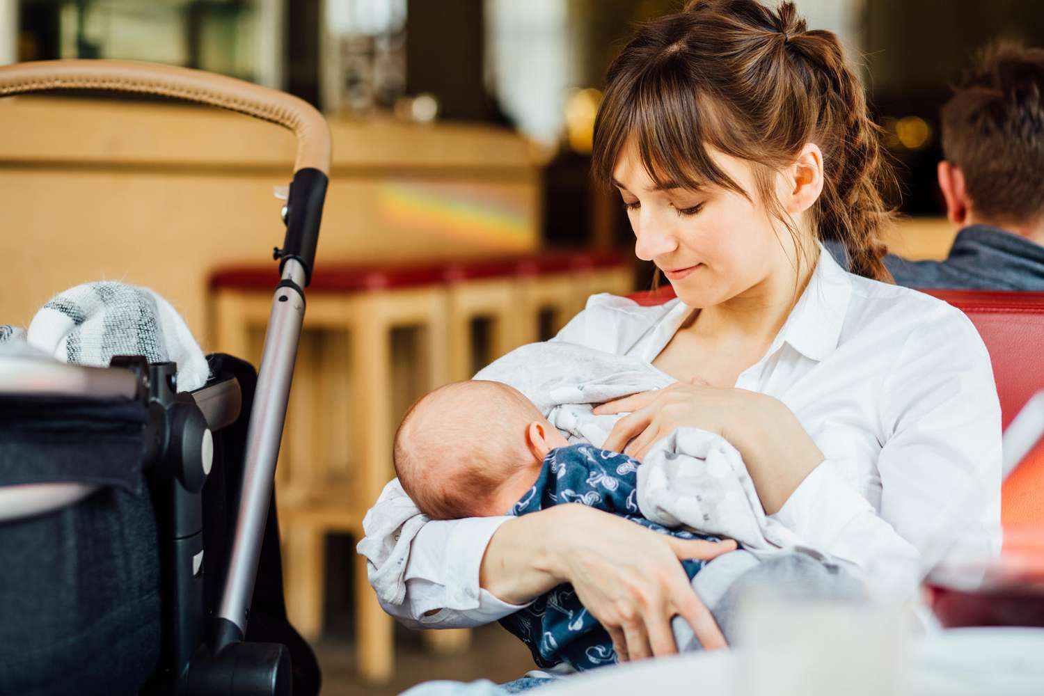 Young Mother Public Breastfeeding In Cafe