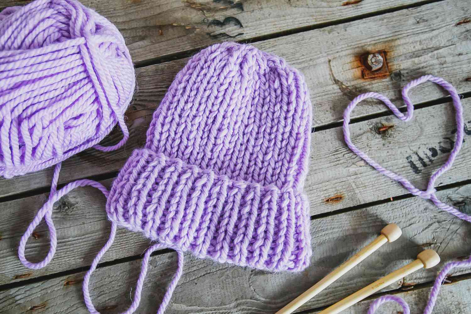 Purple Knit Hat Cap on Wooden Table