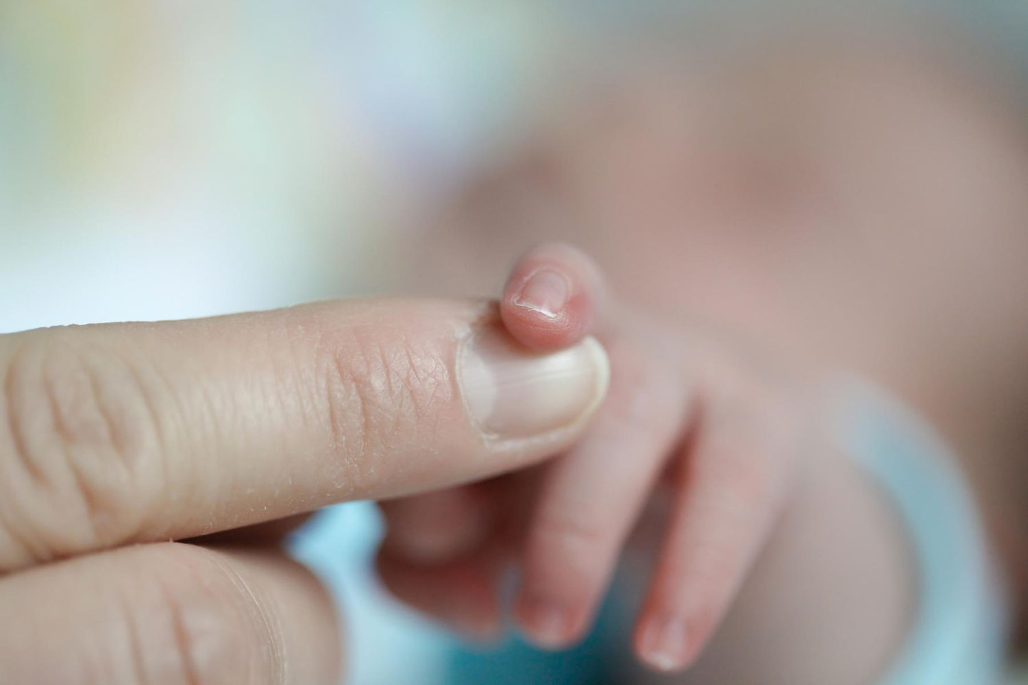 Newborn finger with dad hand
