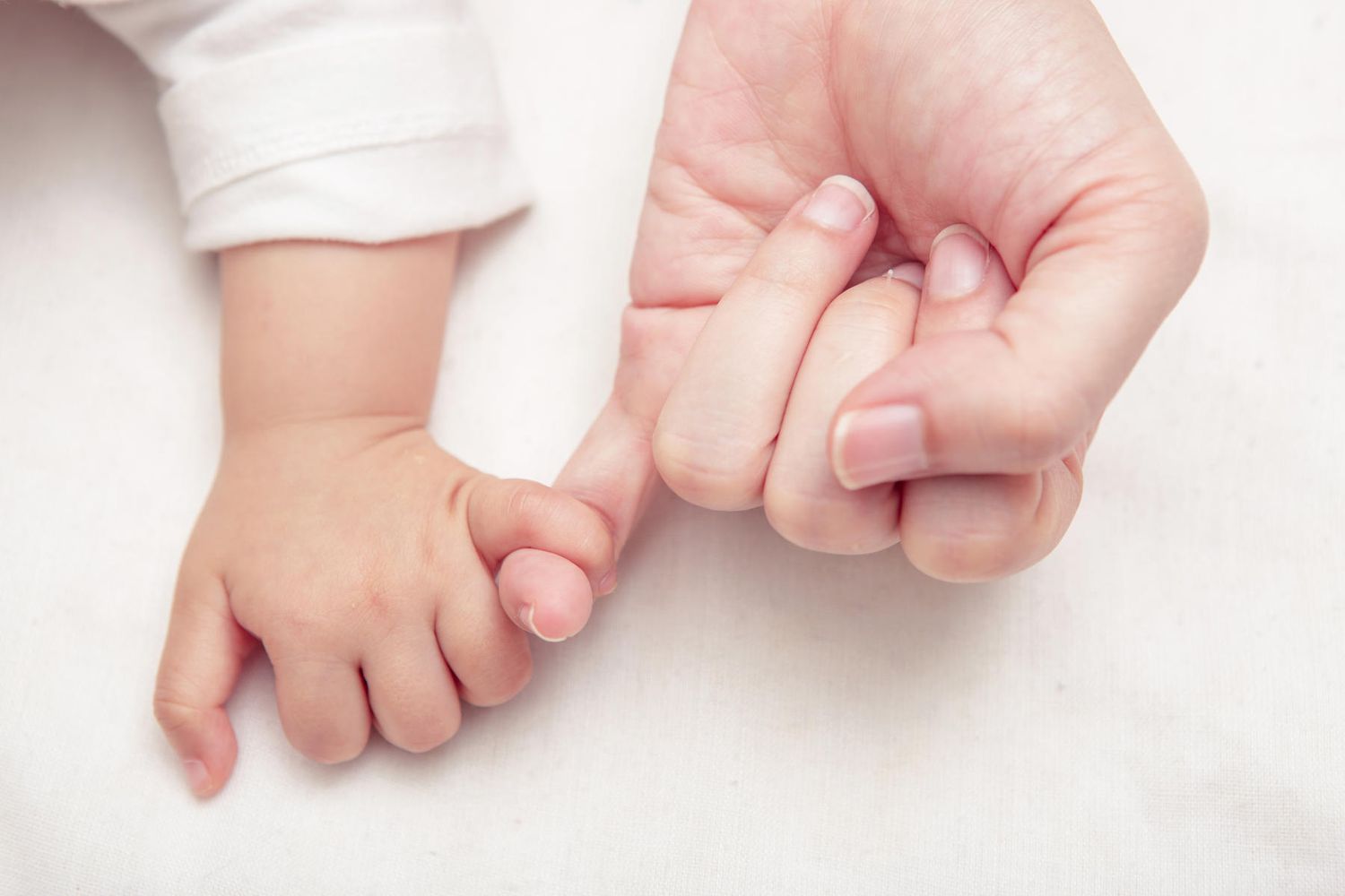 mom and baby holding pinky fingers