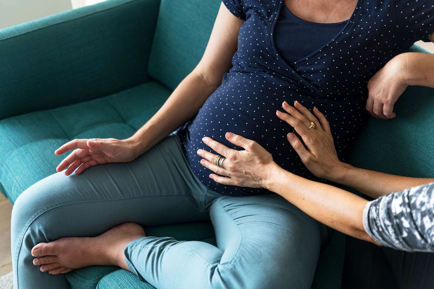 Pregnant Woman on Couch and Hands On Belly