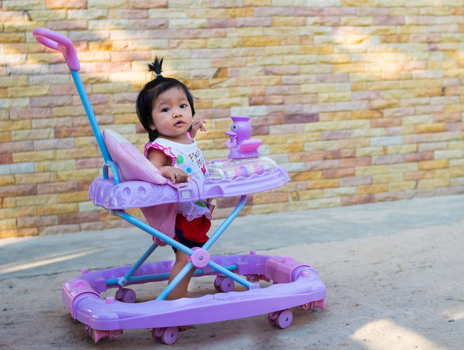 Asian Baby Standing in Infant Walker Pink