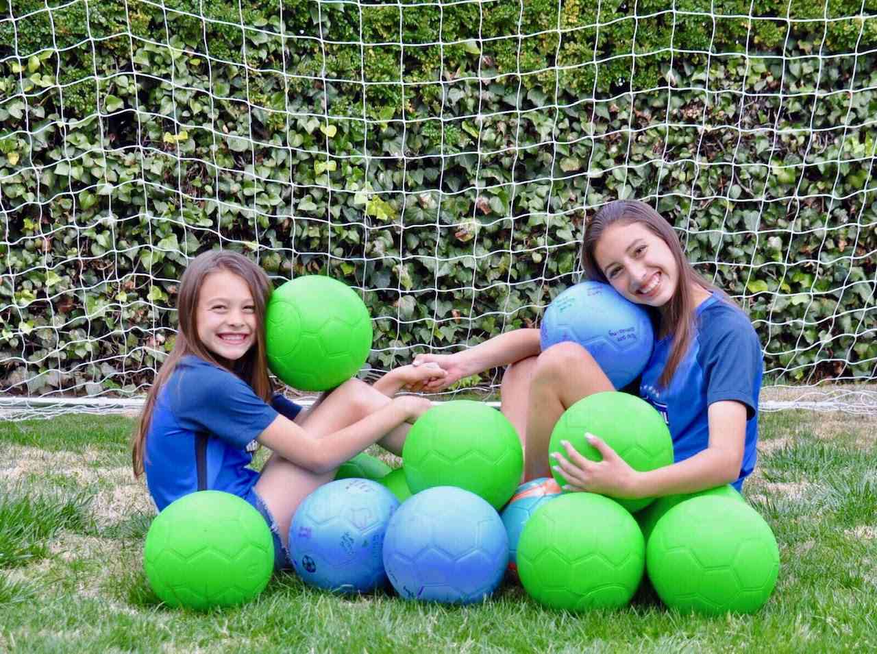 Taylor and Jordyn Jackson with the soccer balls they donate
