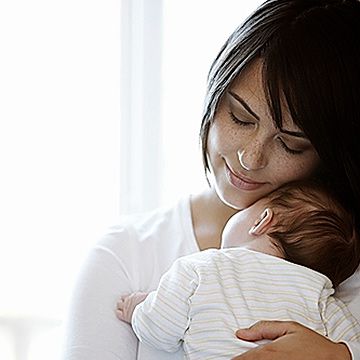 mother holding sleeping newborn