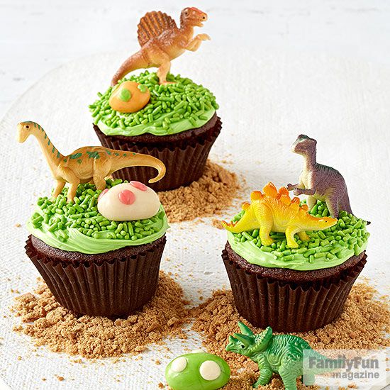 Trio of plastic dinosaur-topped chocolate cupcakes