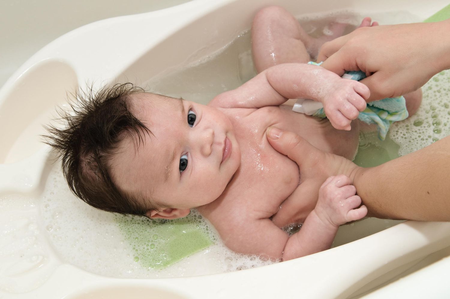 New baby getting first bath in baby bathtub