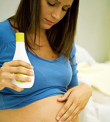 pregnant woman moisturizing belly