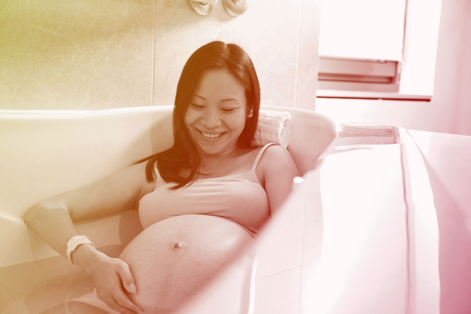 woman having water birth in bathtub