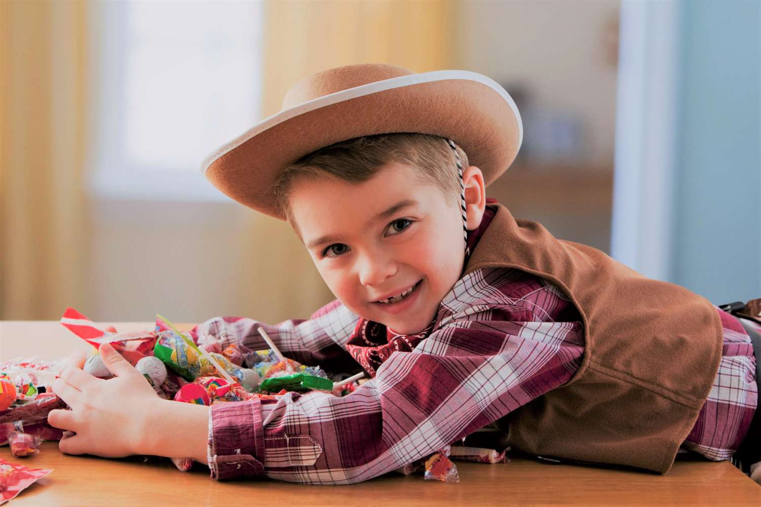 Boy in cowboy costume grabbing Halloween candy