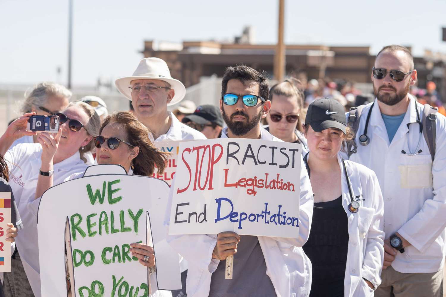 Doctors, nurses, medical students hold up posters June 23, 2018 at the Tornillo Port of Entry in Tornillo, Texas, to demand quick reunification of the some 2,700 children with their families. - The Trump administration's erecting of a tent city to house minors separated from their parents has drawn sharp criticism, and is still under fire, despite President Trump's executive order to stop family separation.