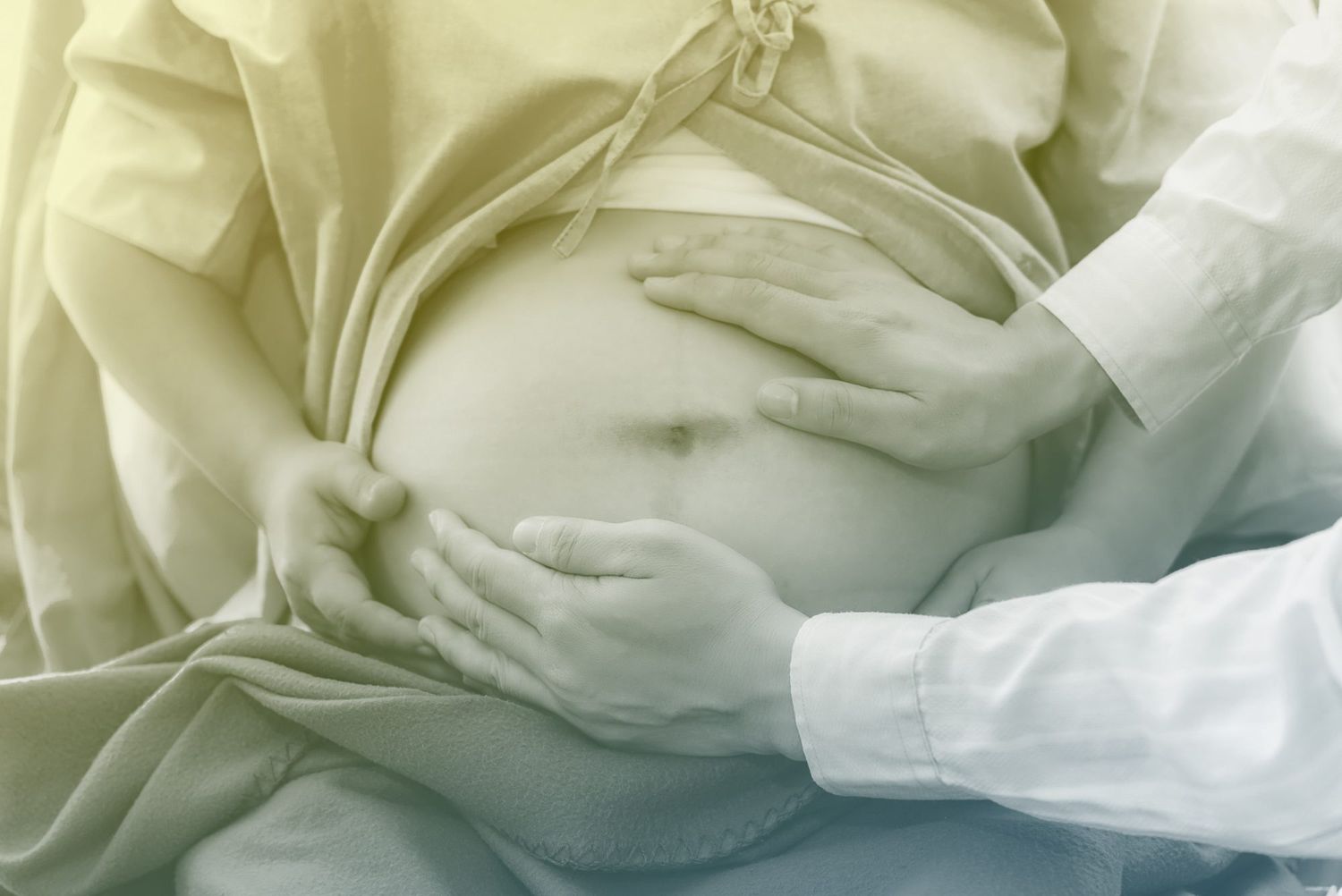 Doctor Touching Belly Of Pregnant Woman At Hospital