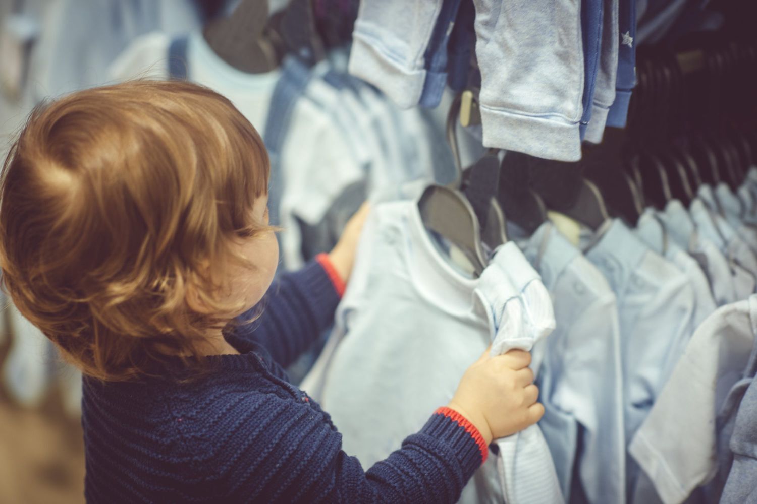 little boy choosing clothes during shopping