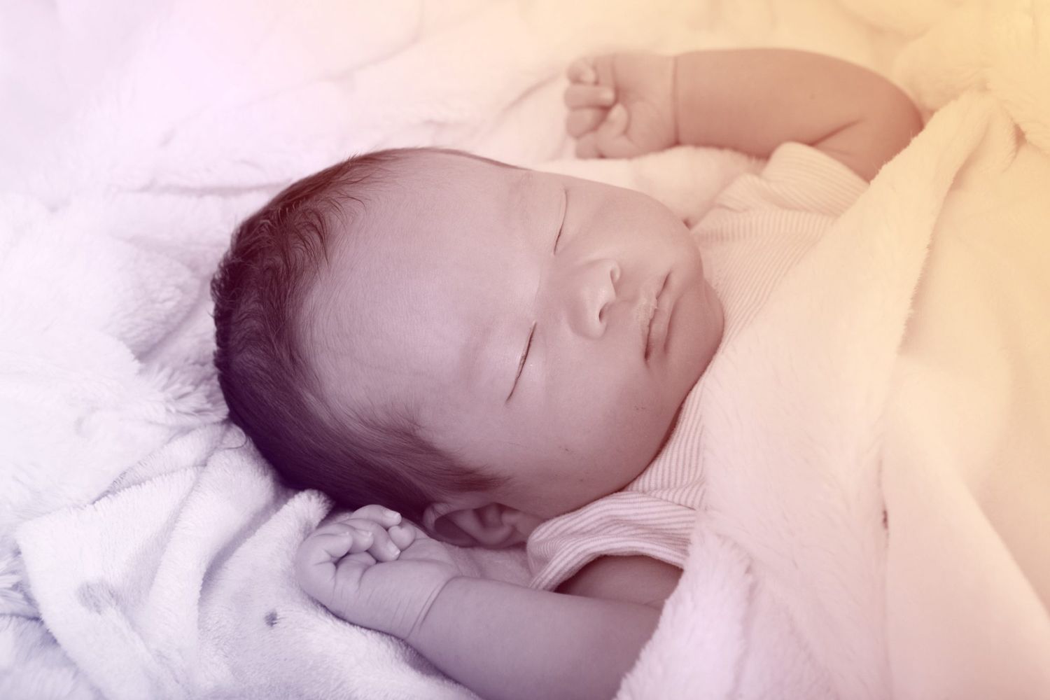 asian infant sleeping with arms up