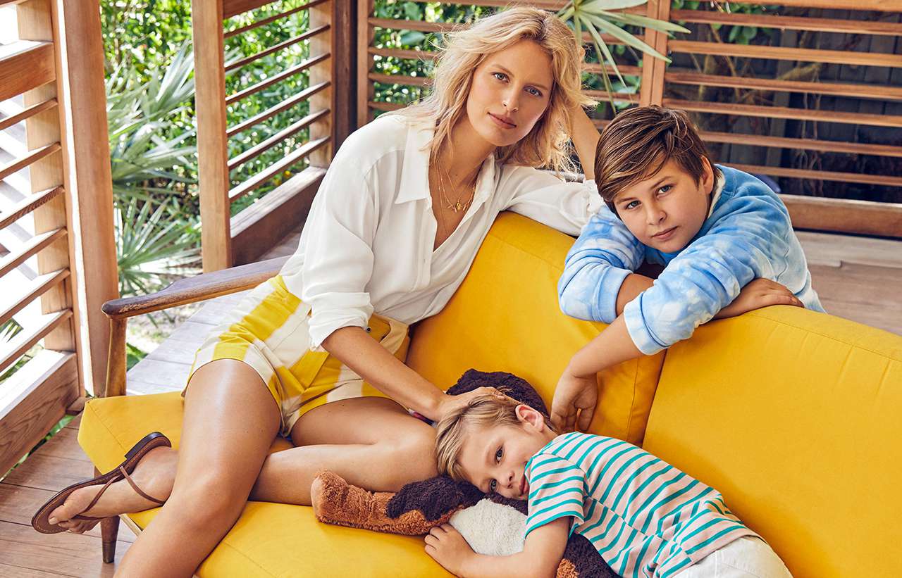 Karolína Kurková sitting on deck couch with two kids