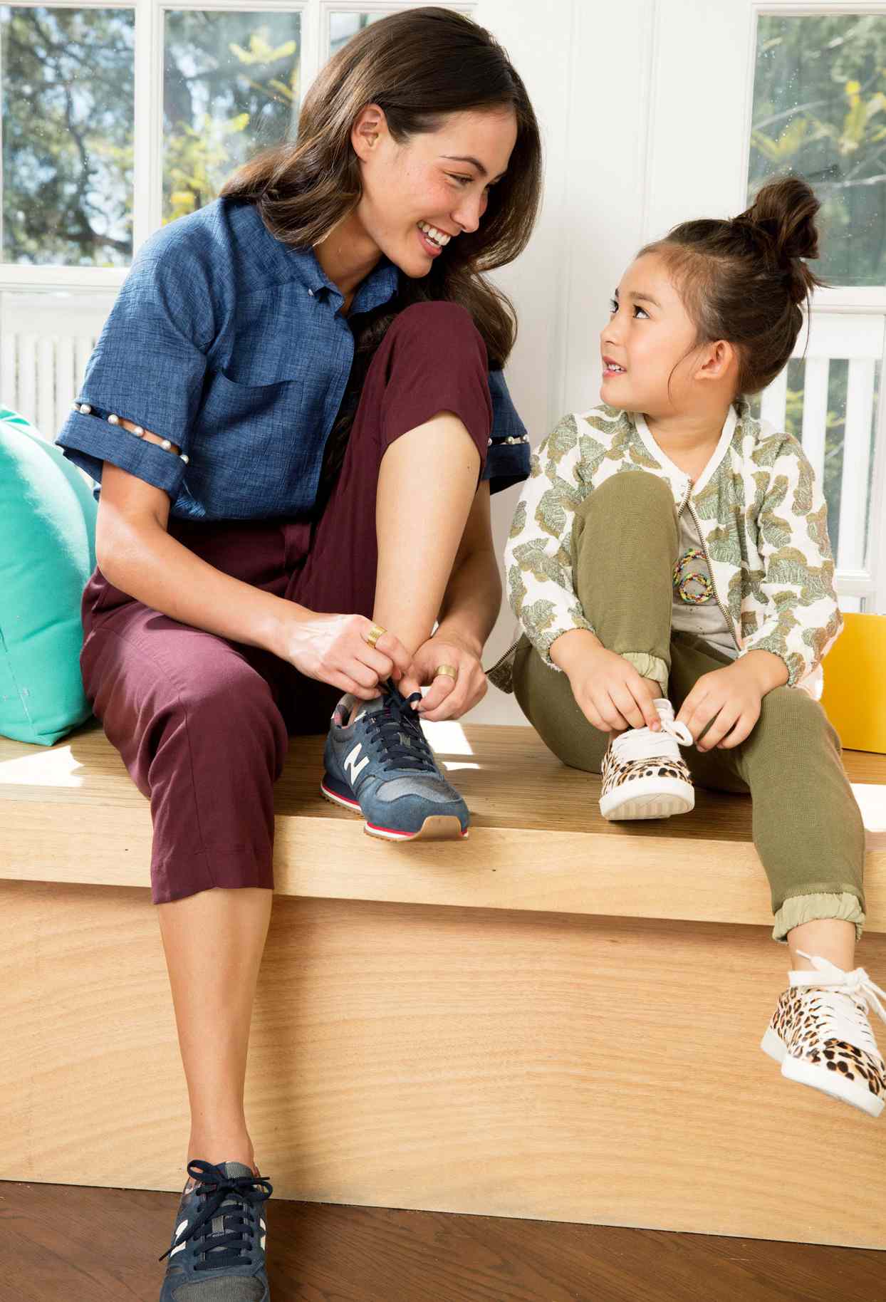 woman tying her shoes with a child