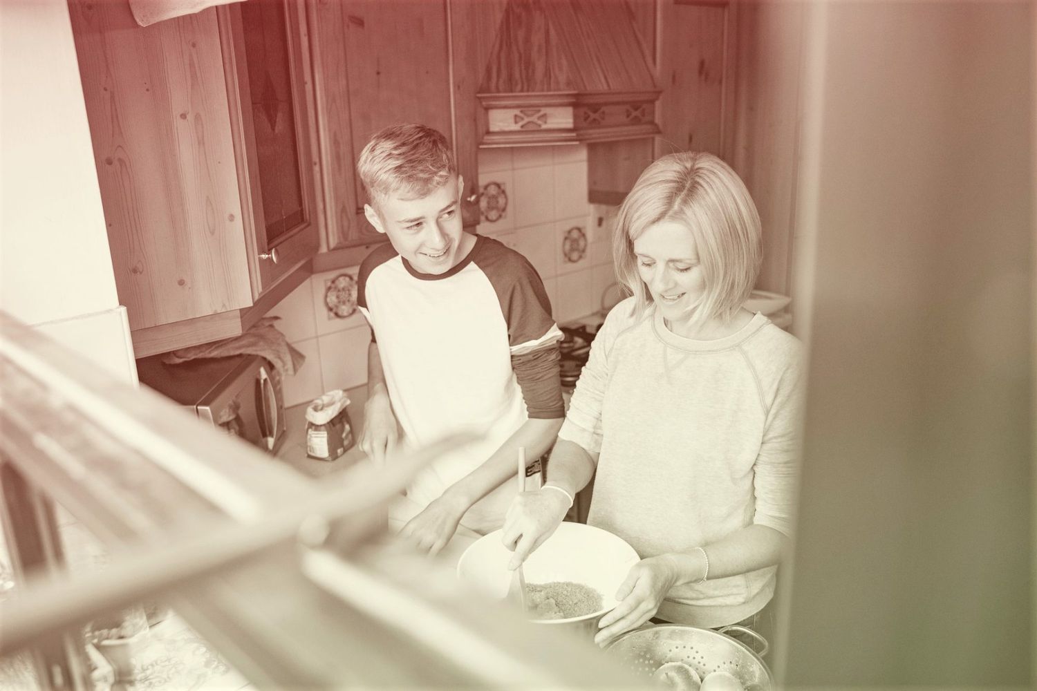 mother and teen cooking together in kitchen
