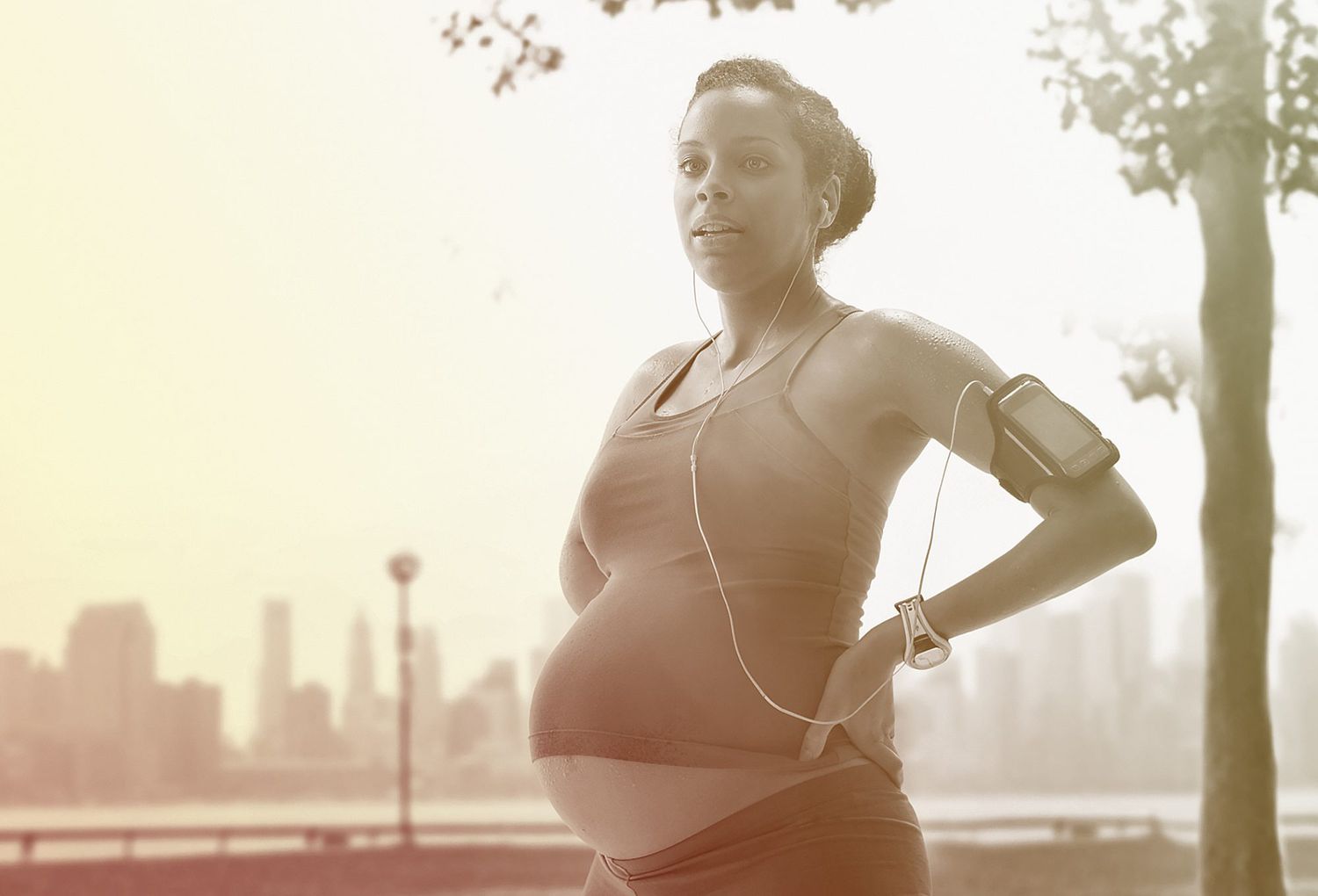 Pregnant mixed race woman exercising in park