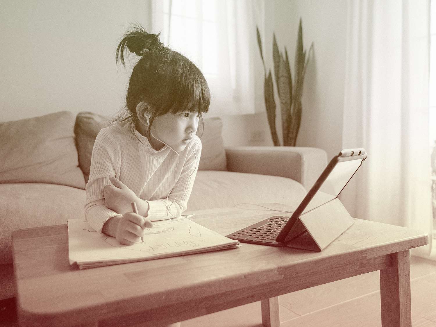 Little girl doing her homework with digital tablet