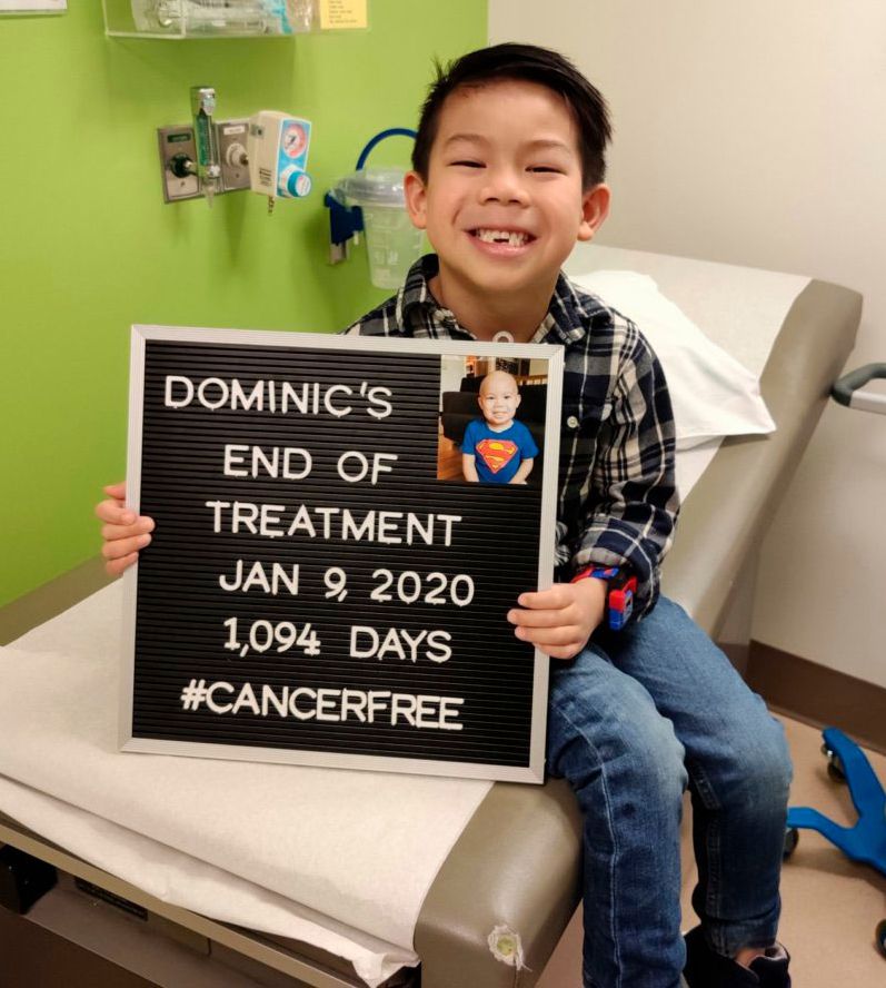 child with sign celebrating end of cancer treatment