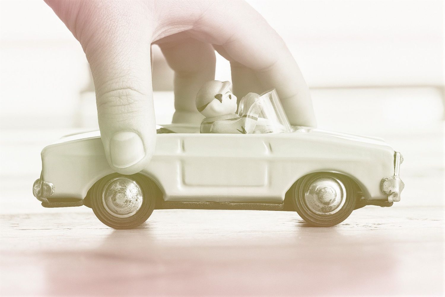 Hand pushing vintage toy convertible car