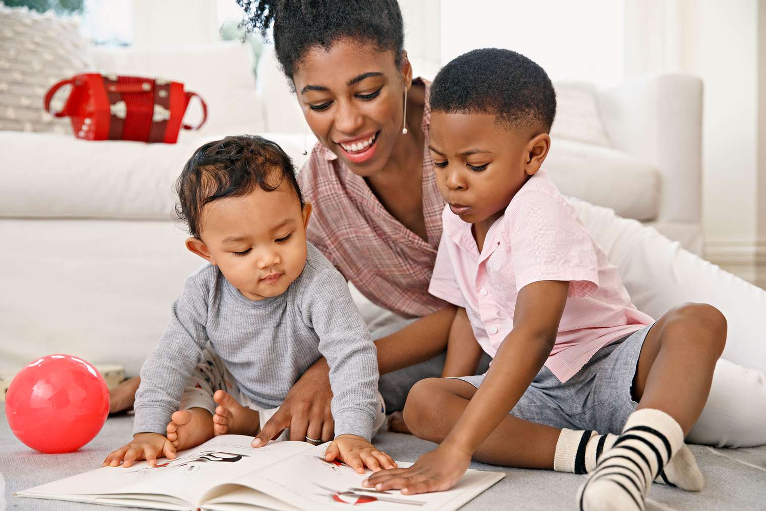 mother reading picture book with two boys