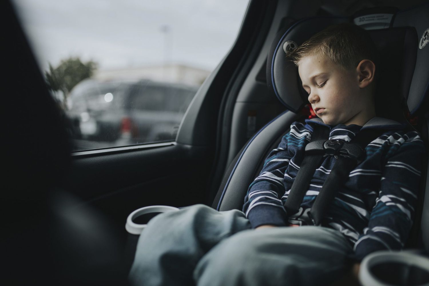 An image of a boy in a car seat asleep.