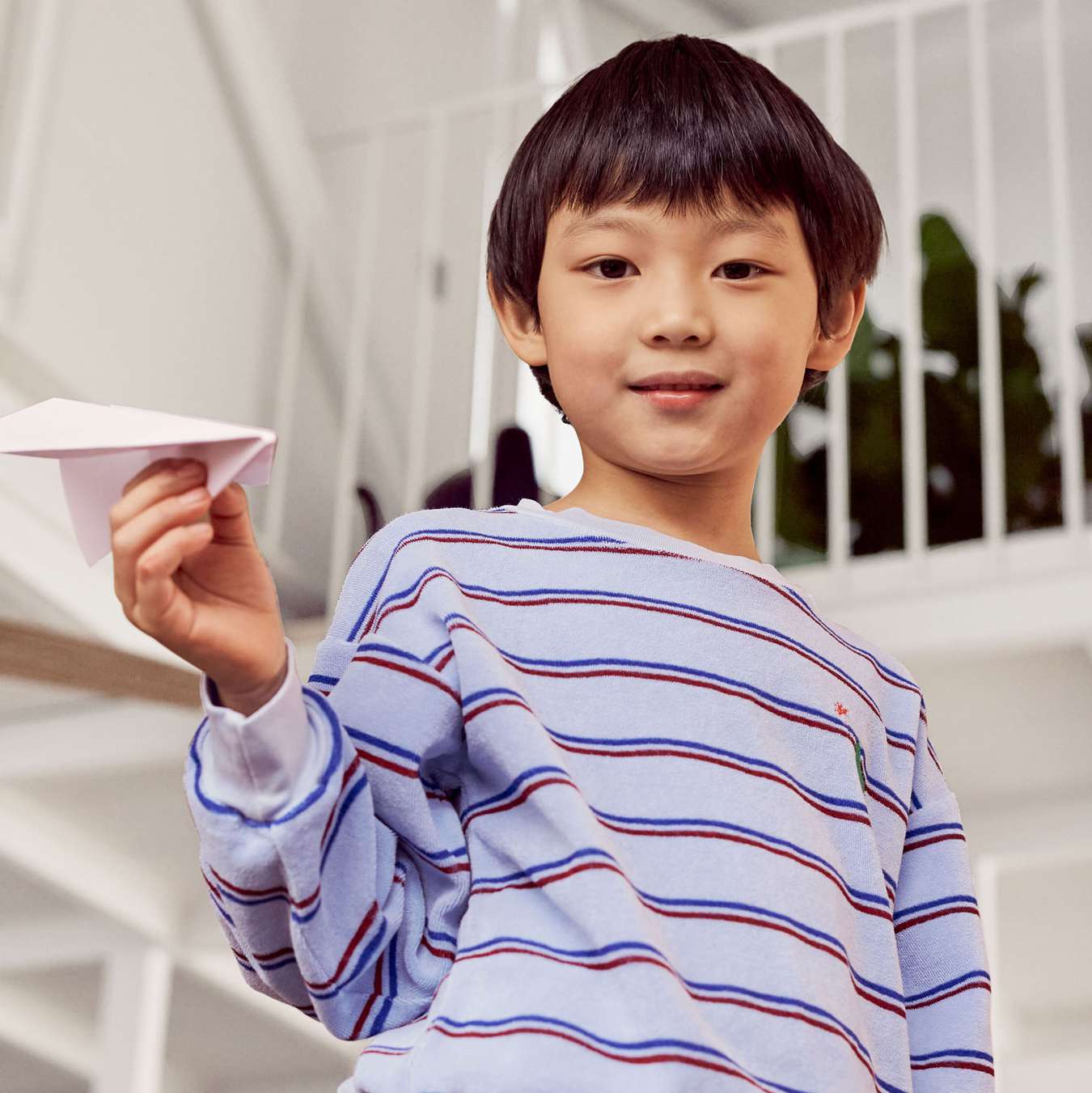 child holding diy paper airplane