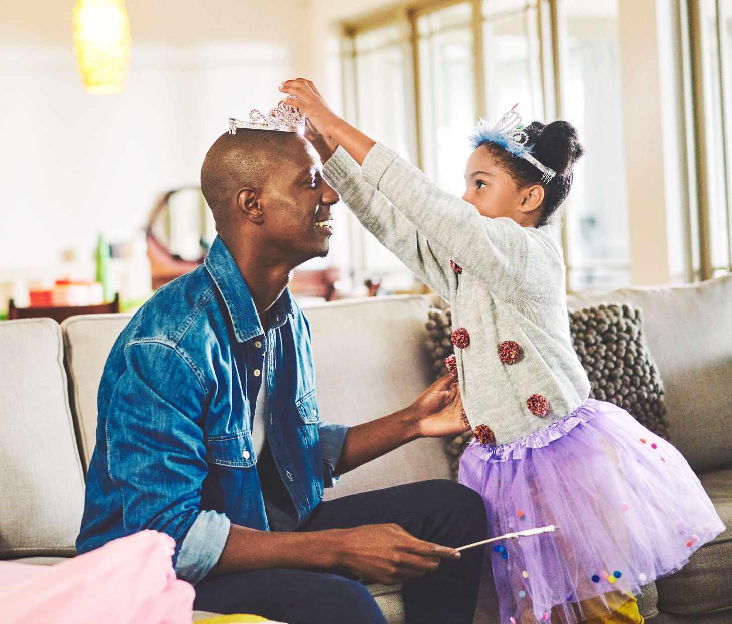 father and daughter playing dress up in living room