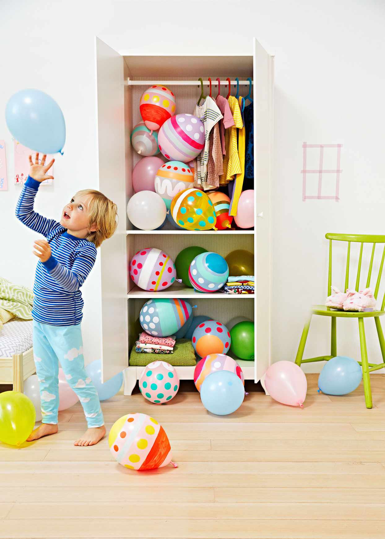 kid playing with easter egg balloons