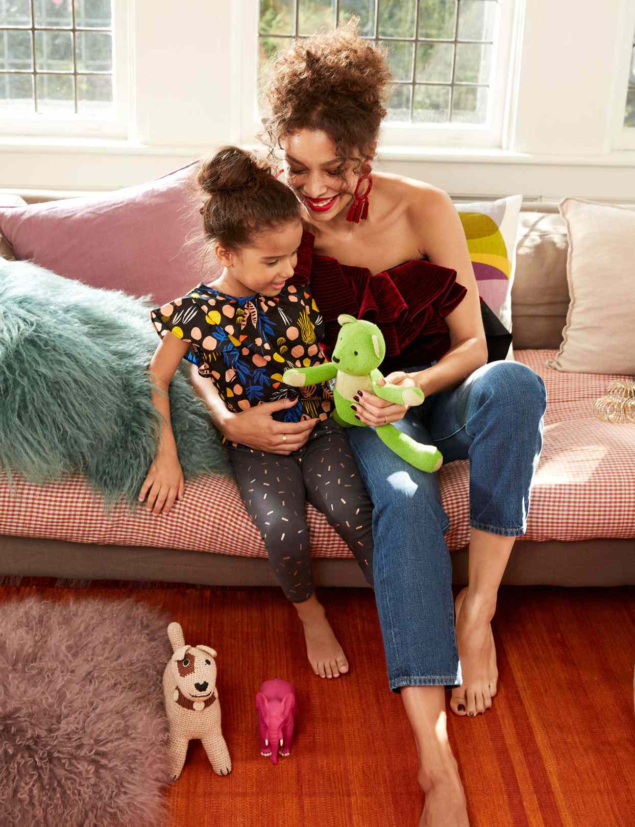 woman on couch with little girl and stuffed animal