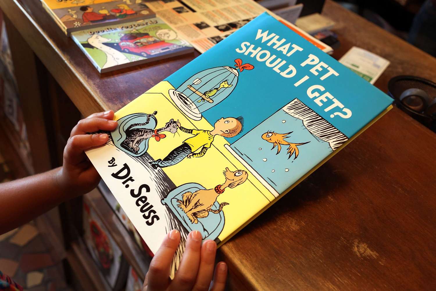 An image of a child holding a Dr. Seuss book.