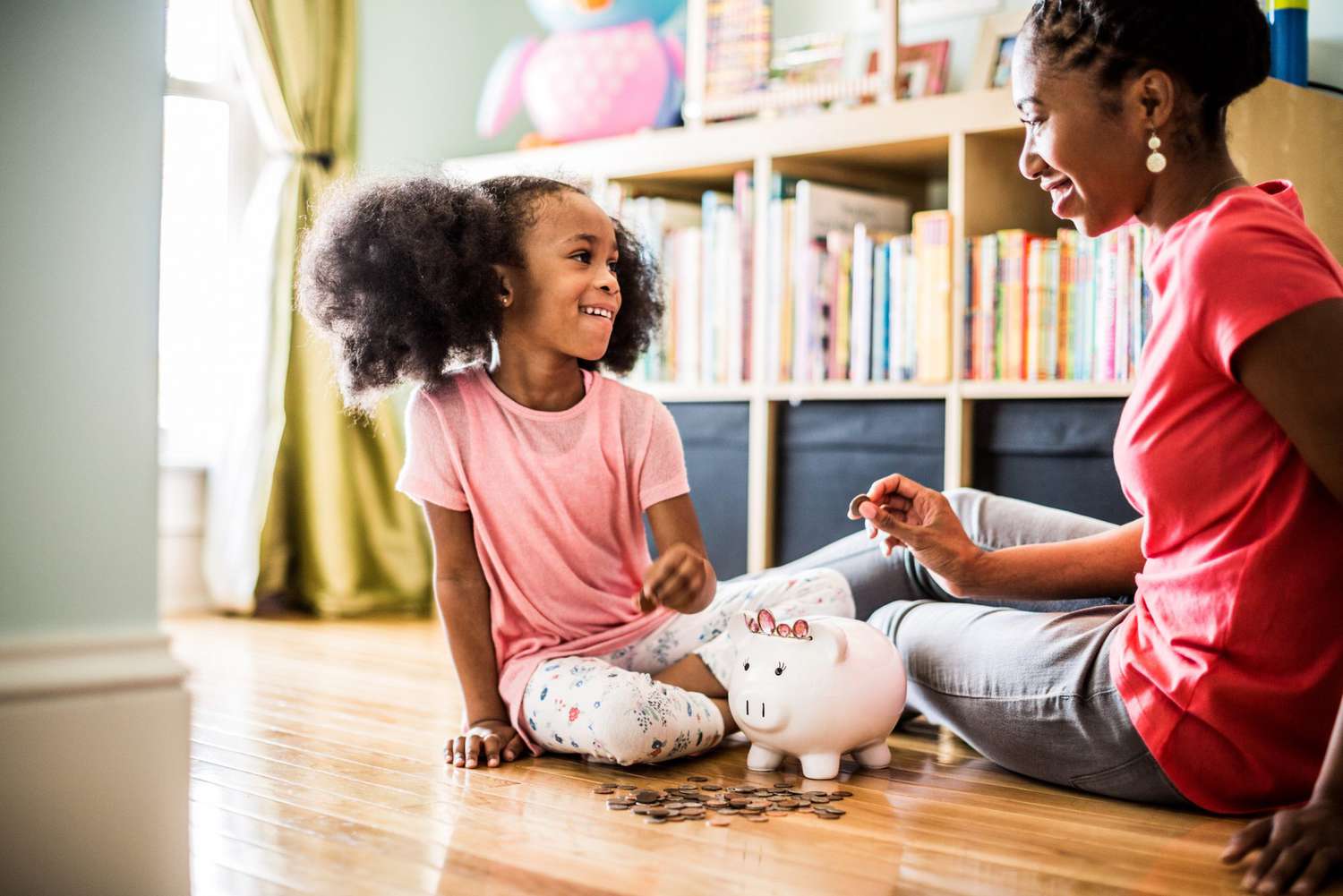 An image of a mother and daughter with a piggy bank.
