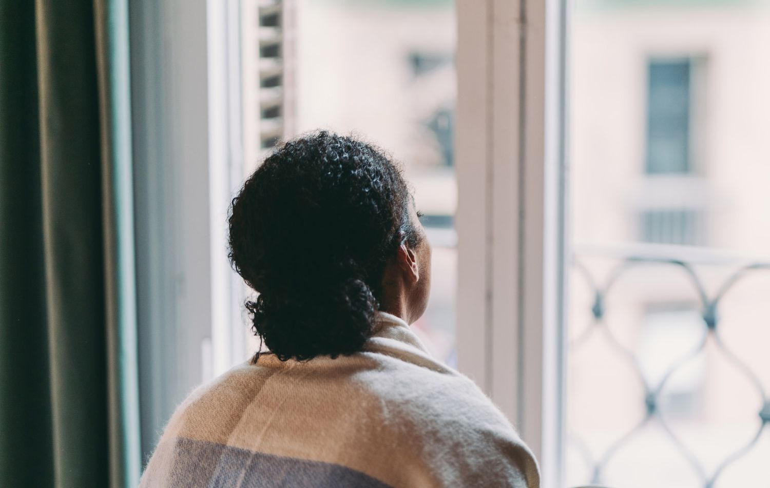 An image of a woman looking out a window.