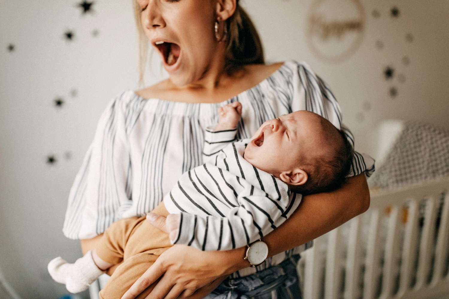 An image of a tired mother holding her baby.