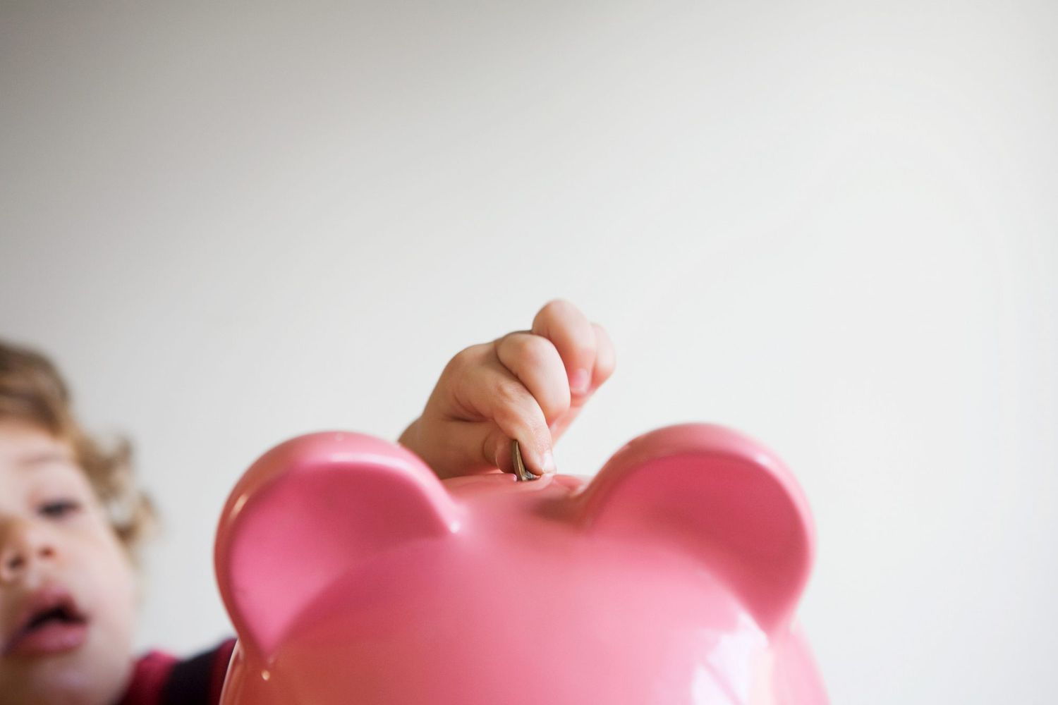 An image of a child with a piggy bank.