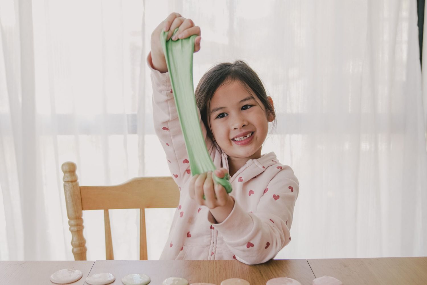 An image of a little girl playing with slime.