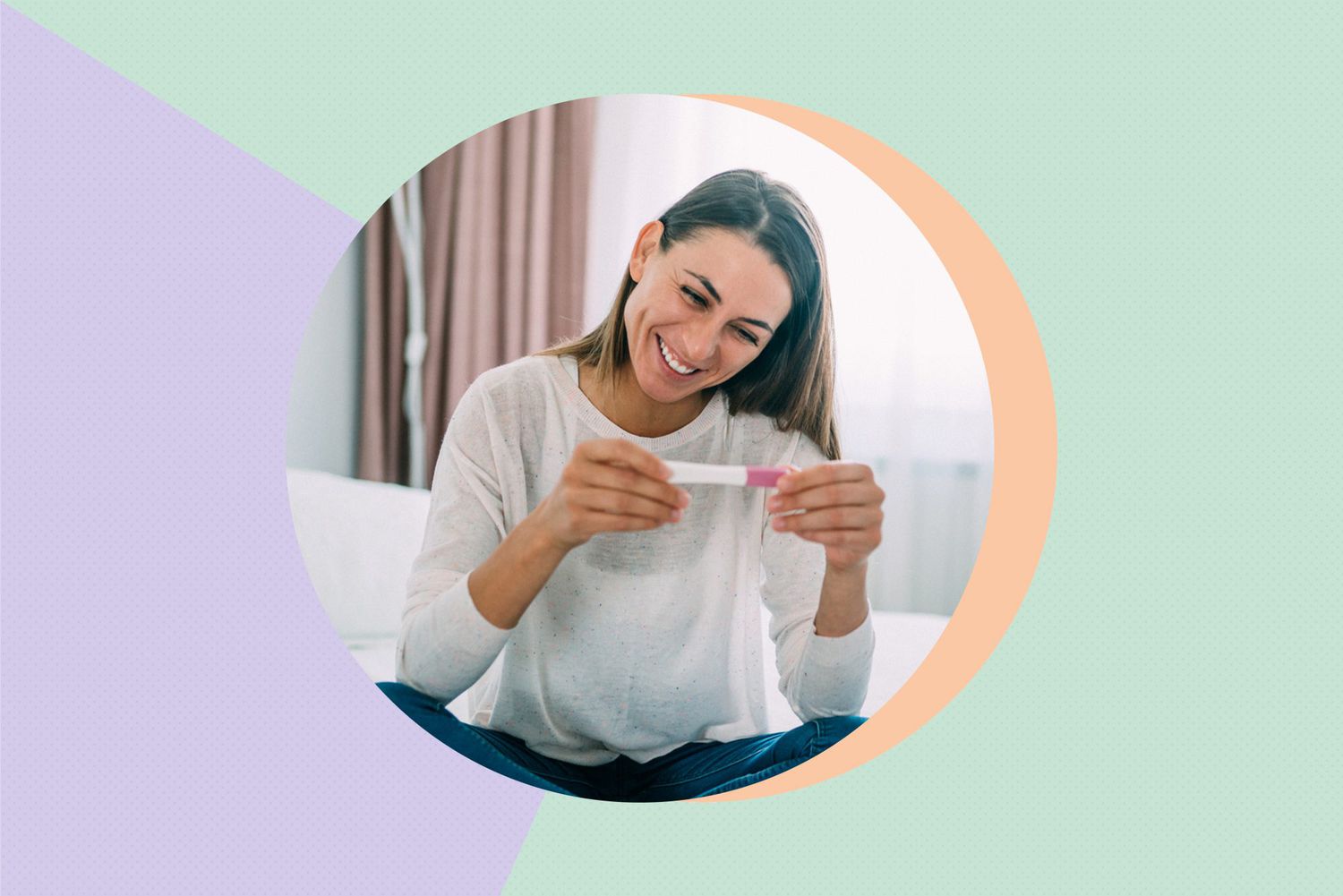 smiling woman looking at pregnancy test